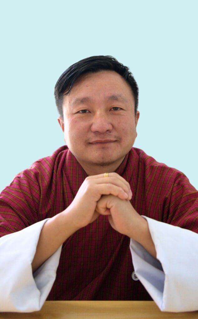 The man wearing Bhutanese Traditional Dress with his hand crossed is the founder of Impact Hub thimphu