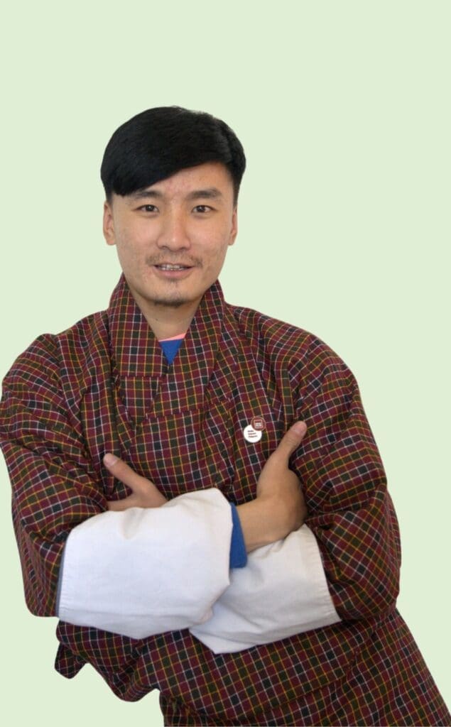 A man with his hand crossed and wearing Bhutanese Gho is Program and Engaging Officer of Impact Hub Thimphu